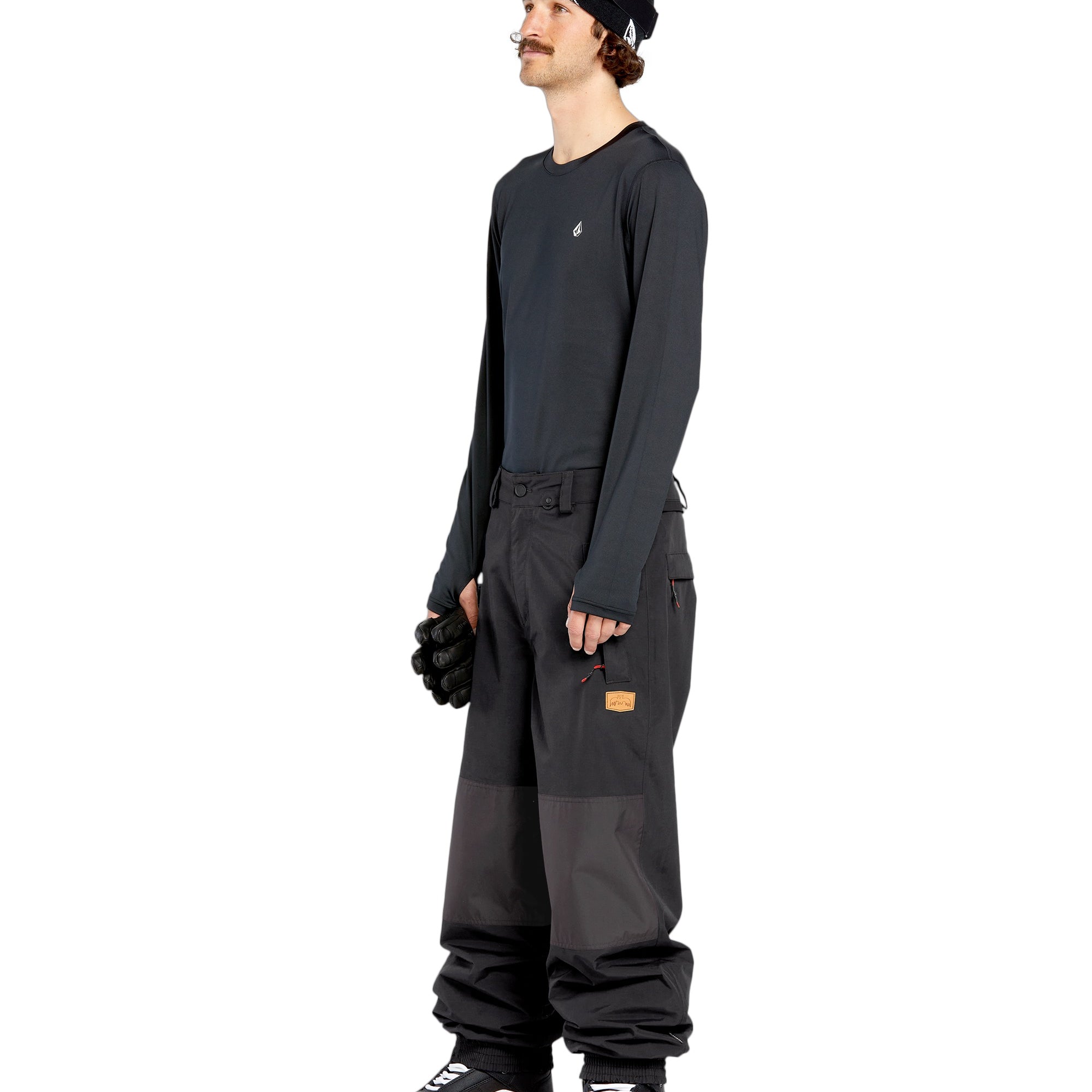 Volcom Men's Longo GORE-TEX Shell Pants - Black pants with a brown logo on the left leg and two zippered pockets on the right side.