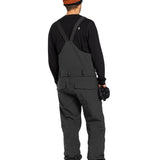Volcom Men's Roan Shell Bib Overall - A black bib overall with a white logo on the chest and two zippered pockets on the front.