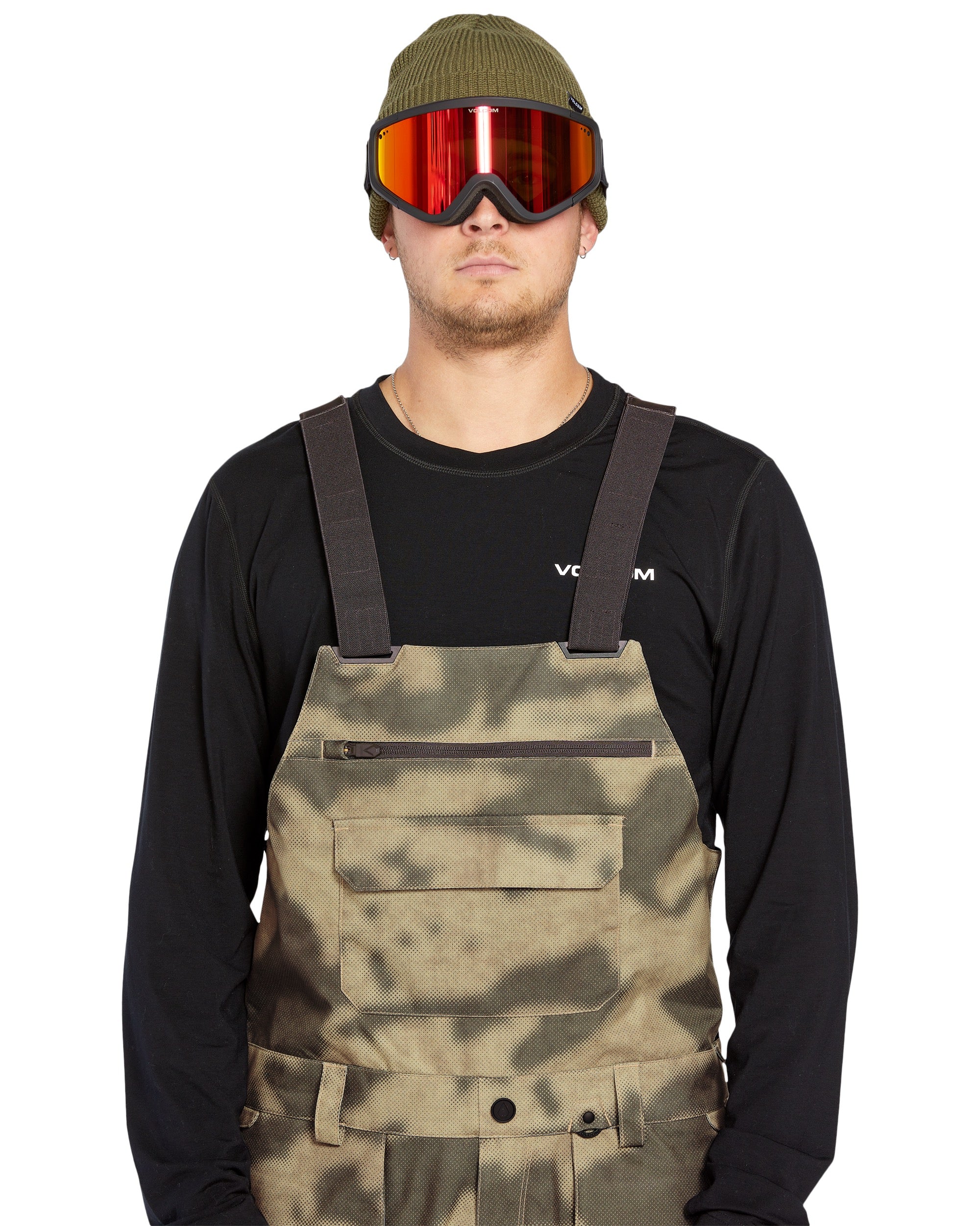Volcom Men's Roan Shell Bib Overall - A pair of khaki-colored bib overalls with a camouflage pattern, featuring two front pockets and adjustable straps.