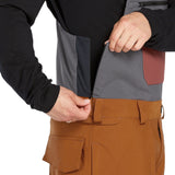 Volcom Men's Roan Shell Bib Overall - A black bib overall with a grey chest pocket and brown accents on the side pockets.