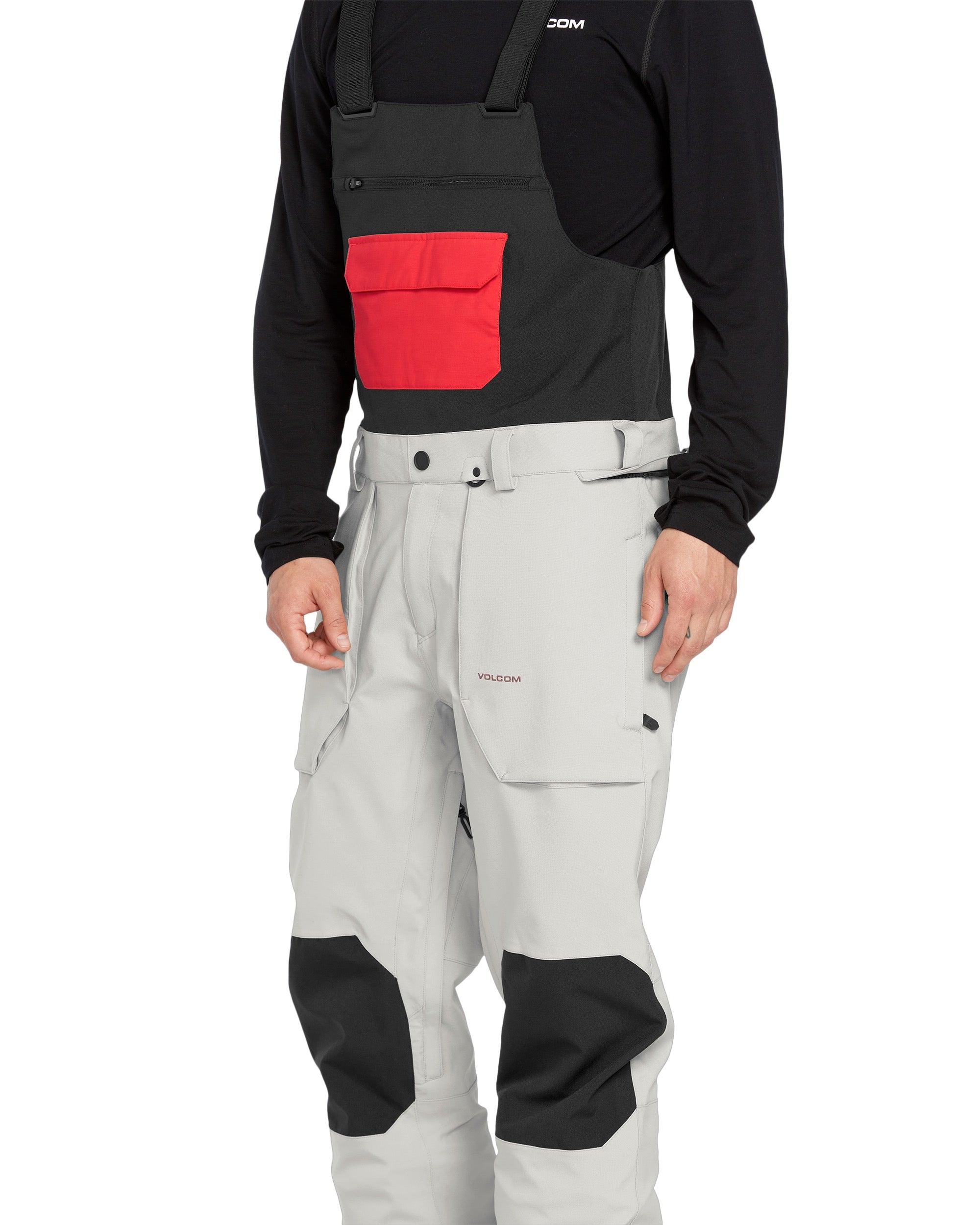 Volcom Men's Roan Shell Bib Overall - A black bib overall with a red logo on the chest and two zippered pockets on the front.