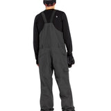 Volcom Men's V.Co Sparta Bib Overall - A pair of dark gray snowboard pants with a black strap and buckle on the waist, featuring a zippered pocket on the thigh.