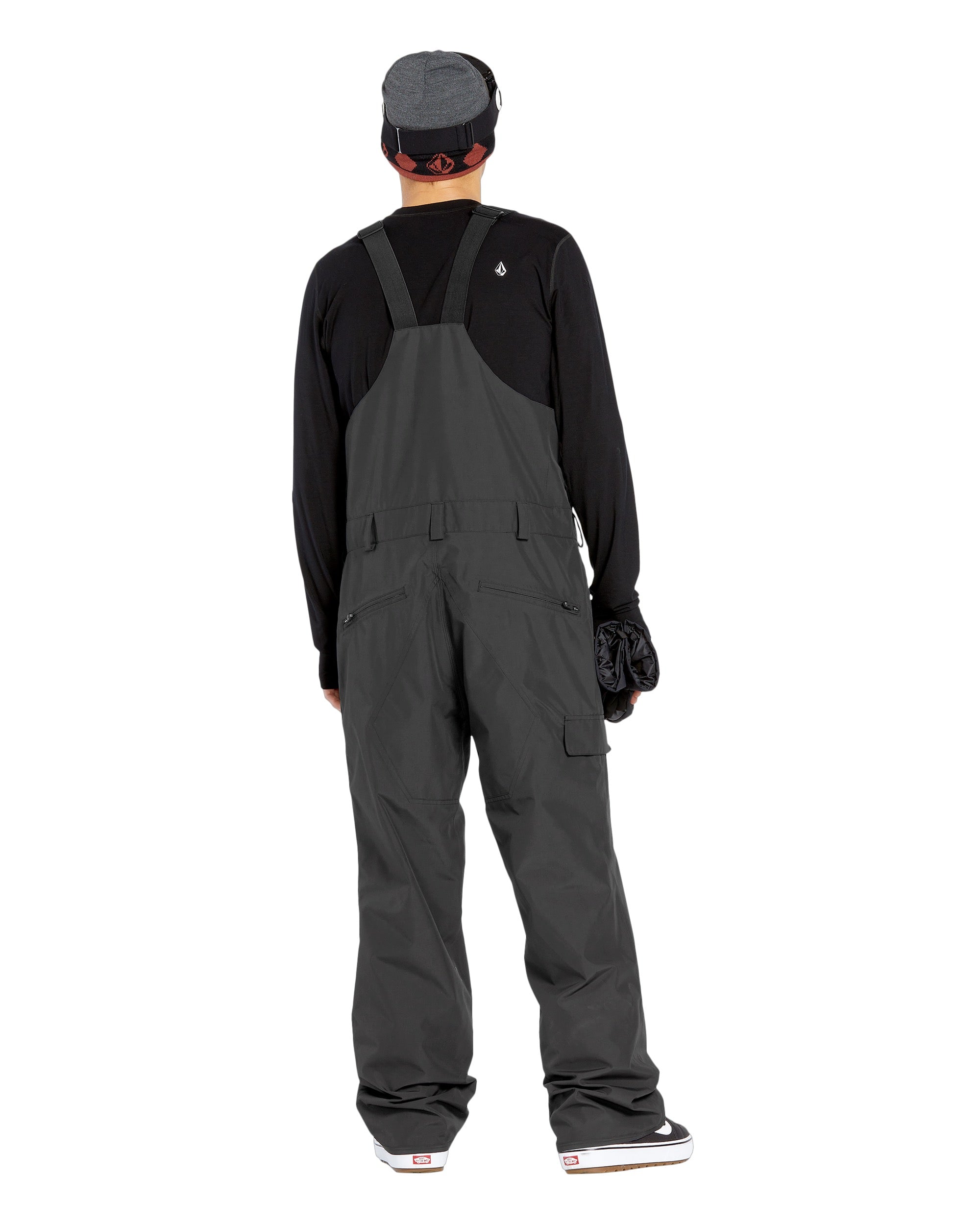 Volcom Men's V.Co Sparta Bib Overall - A pair of dark gray snowboard pants with a black strap and buckle on the waist, featuring a zippered pocket on the thigh.