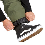 Volcom Men's V.Co Sparta Bib Overall - A pair of olive green snow pants with a black zipper and white drawstring on the waistband.