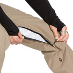 Volcom Men's Freakin' Snow Chino Pant - Beige snow pants with a zippered pocket on the side and a black logo patch on the left thigh.