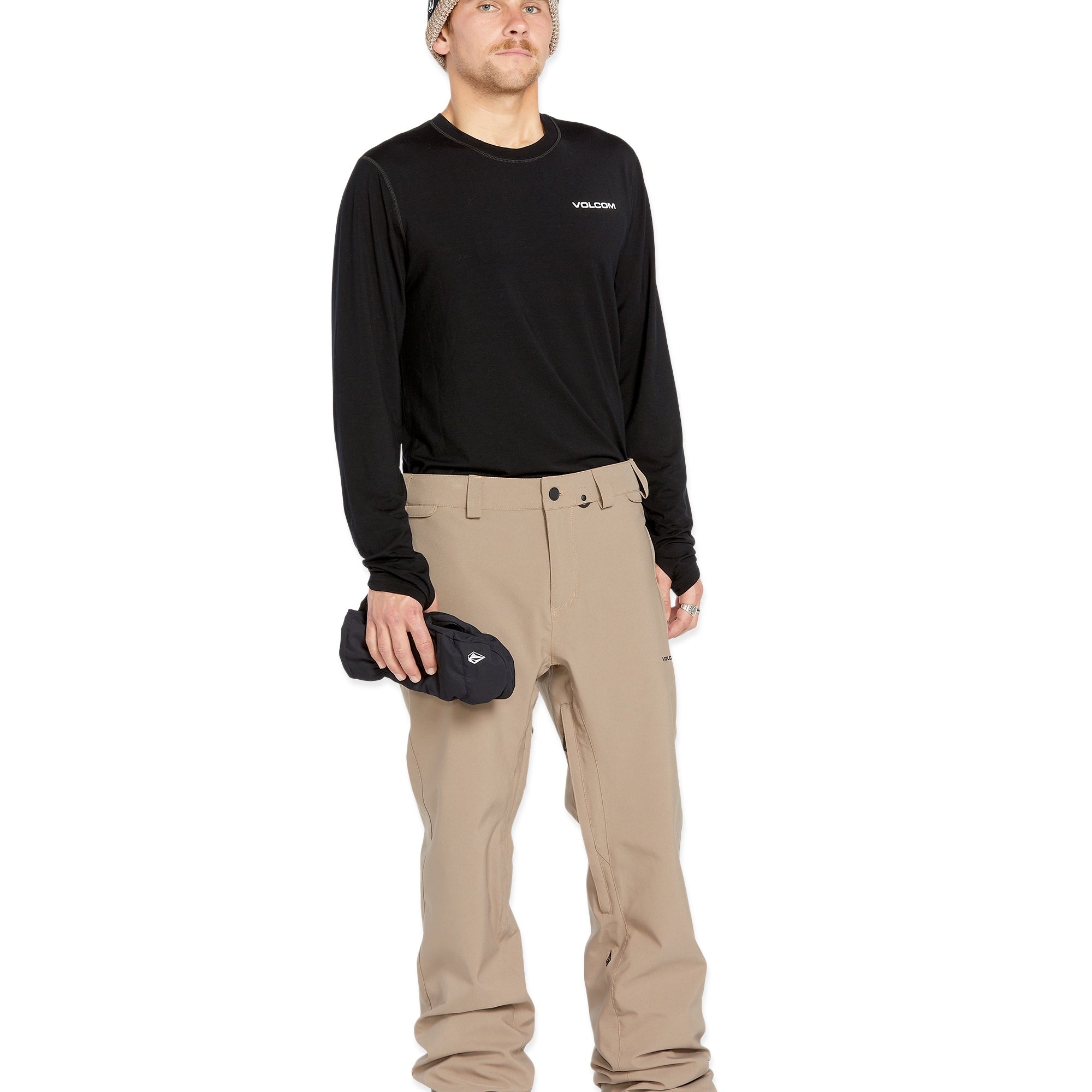 Volcom Men's Freakin' Snow Chino Pant - A pair of khaki-colored snow pants with a zippered pocket on the side and adjustable Velcro straps at the waist.