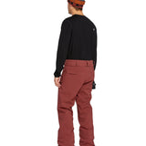 Volcom Men's Freakin' Snow Chino Pant - A pair of brown snow pants with a subtle white stripe on the side.