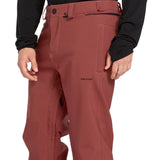 Volcom Men's Freakin' Snow Chino Pant 2025 - A pair of red snow pants with a black zipper on the side and two belt loops at the waist.