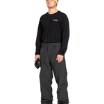 Volcom Men's 5 Pocket Shell Pant - Black pants with white logo on left thigh and two zippered pockets on right side.