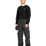 Volcom Men's 5 Pocket Shell Pant - Black pants with white logo on left thigh and two zippered pockets on right side.