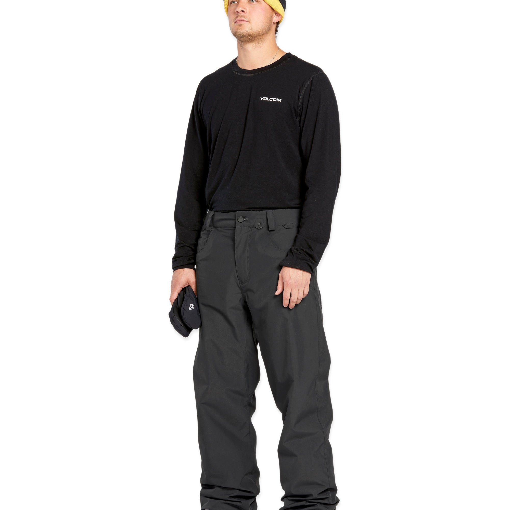 Volcom Men's 5 Pocket Shell Pant - Black pants with white logo on left thigh and two zippered pockets on right side.
