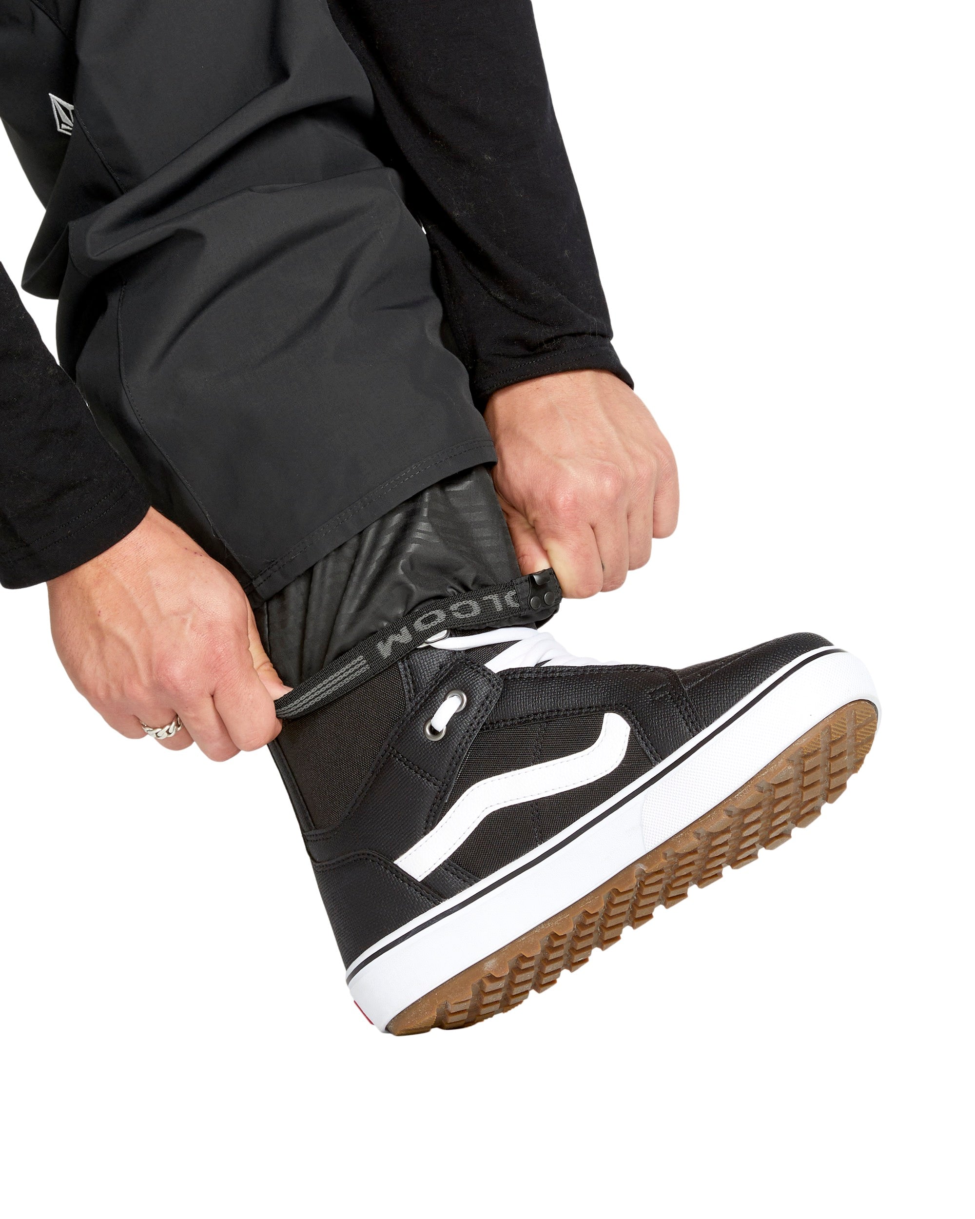 Volcom Men's 5-Pocket Shell Pant - Black pants with a subtle white logo on the left thigh and black drawstrings at the waist.