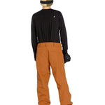 Volcom Men's 5 Pocket Shell Pant - Black pants with white logo on left thigh and two zippered pockets on right side.