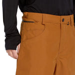 Volcom Men's 5 Pocket Shell Pant - A pair of khaki-colored snow pants with five pockets, including two zippered thigh pockets and three open cargo pockets.