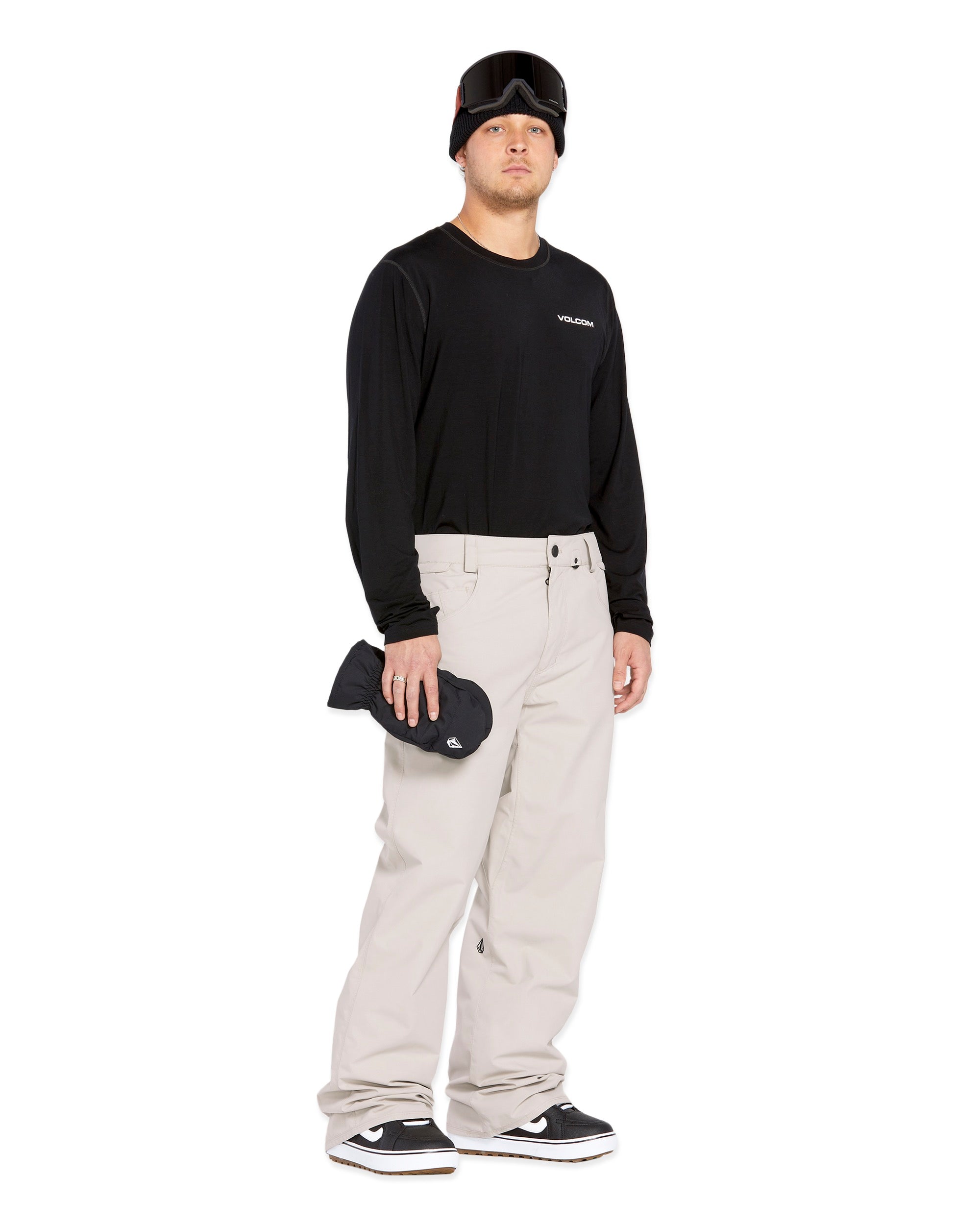 Volcom Men's 5 Pocket Shell Pant - Black pants with white logo on left thigh and two zippered pockets on right side.