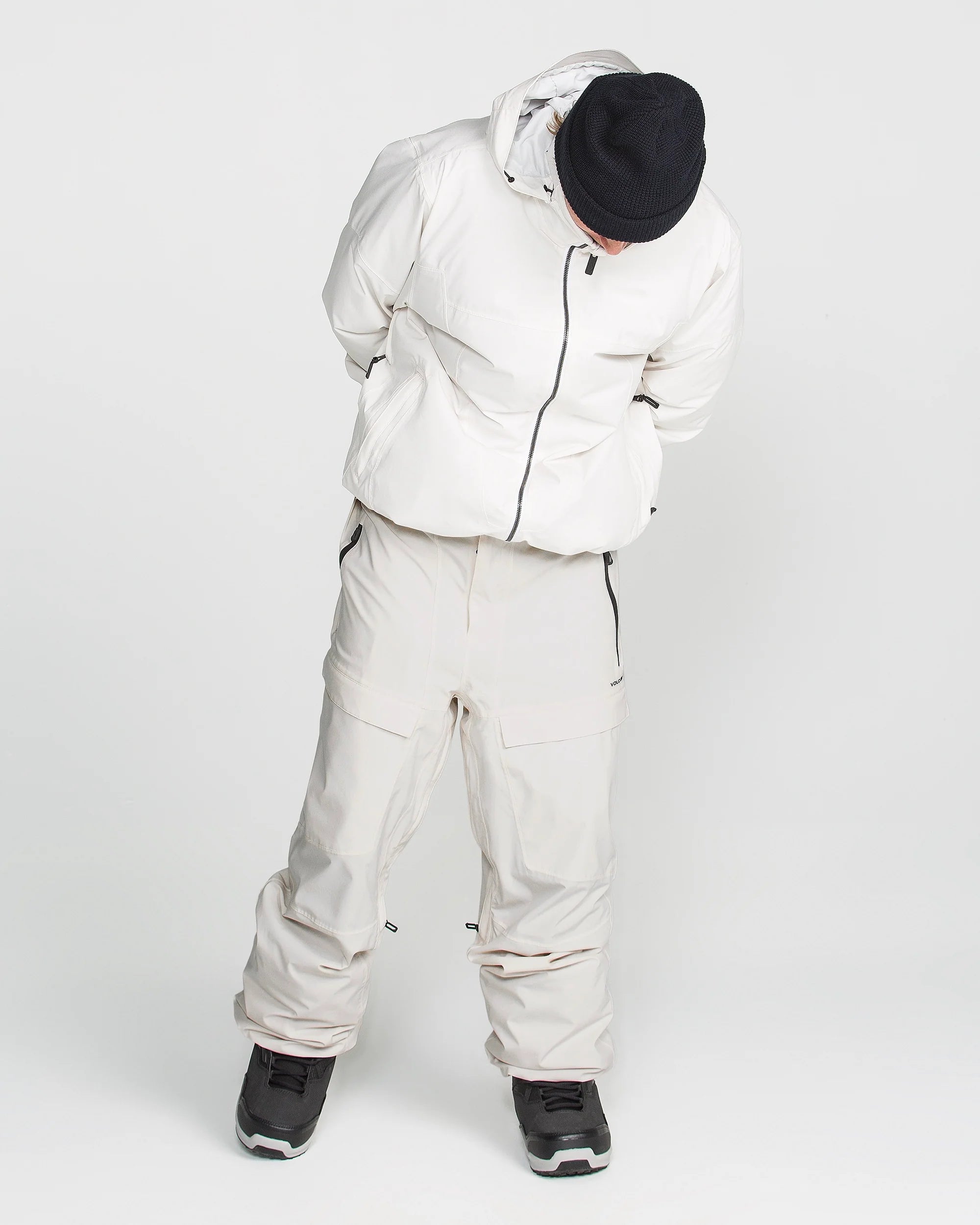 Off-white stretch snow pants with multiple cargo pockets, belt loops, and cuffed hems