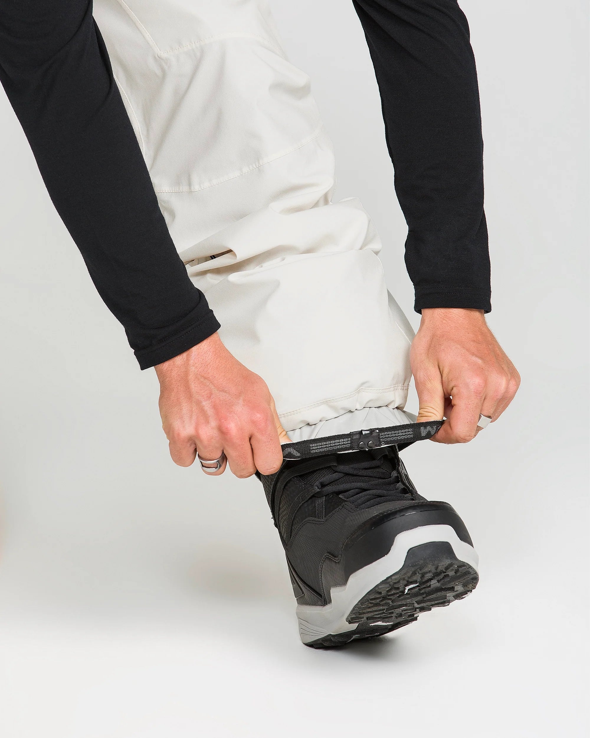 Off-white snowboard pants with secure ankle cuff and reinforced hem.