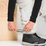 Off-white snowboard pants with tapered legs and adjustable cuffs.