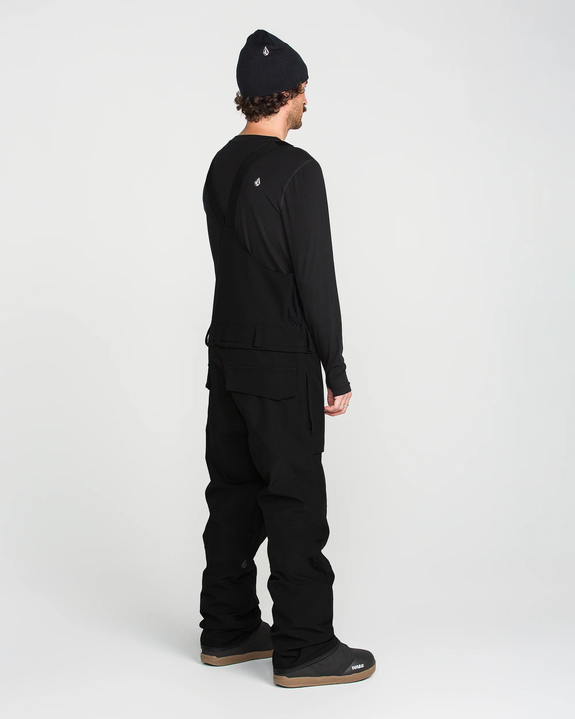 Black bib snow overall back view with shoulder straps and cargo pockets