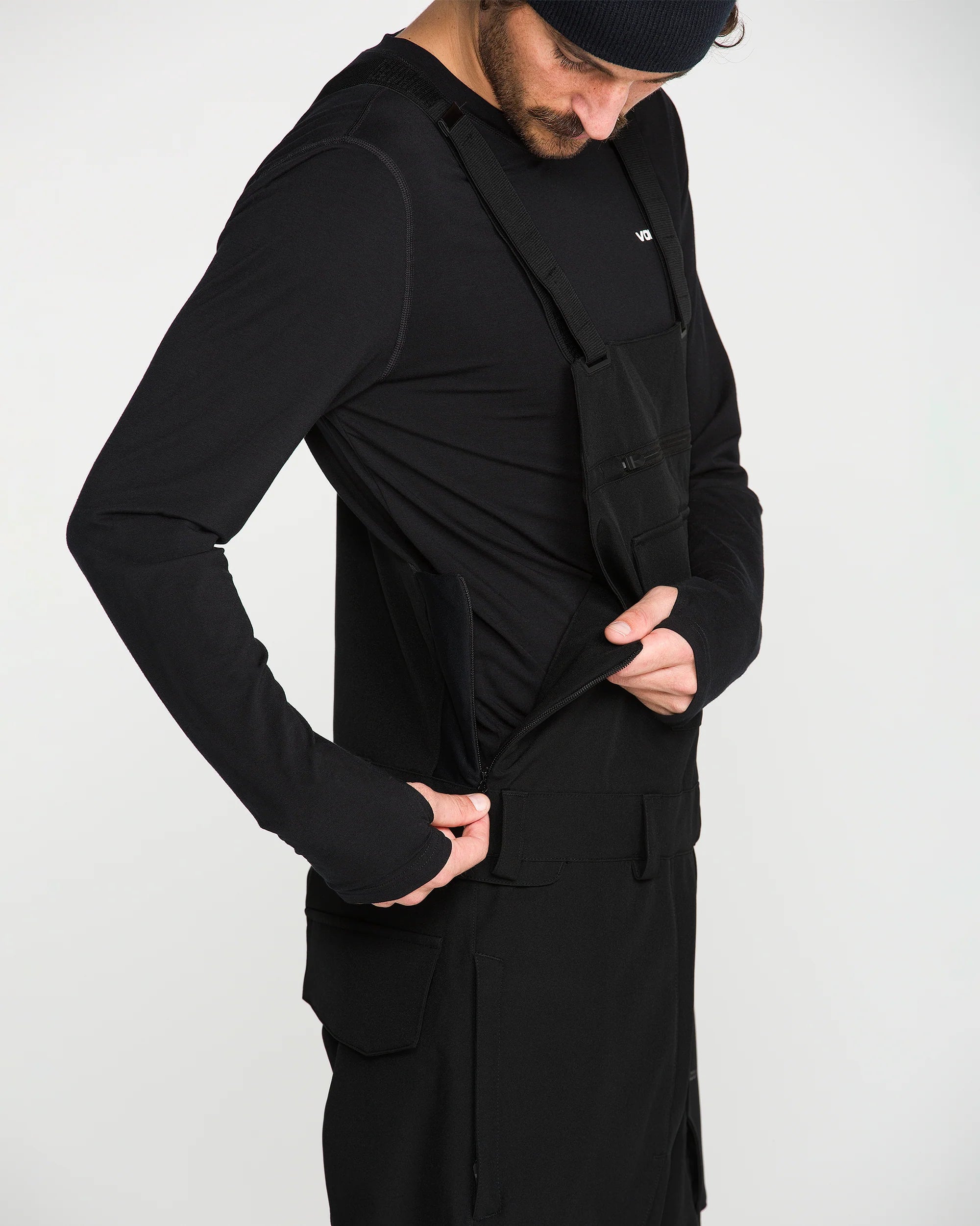 Black bib snow overall with front pockets, adjustable strap, and relaxed fit