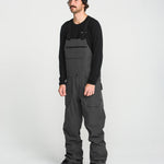 Black bib overall on model with front bib pocket and adjustable strap hardware