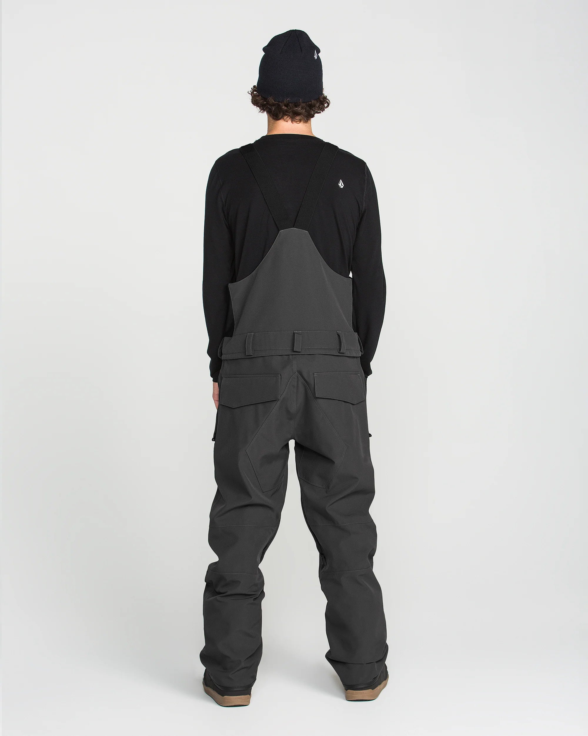 Black bib overall back panel with center seam and cargo pocket stitching