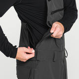 Black bib overall close-up of front pocket flap and adjustable waist straps