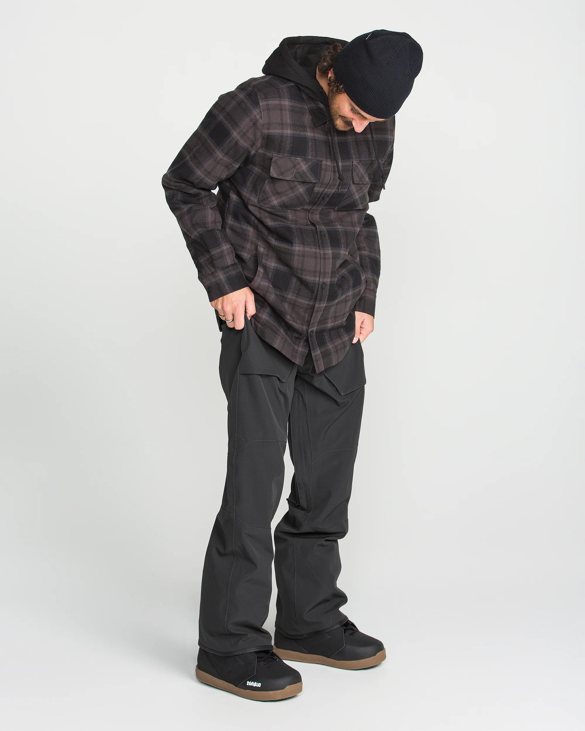 Black bib overall on model, side view with cargo pocket details and ankle cuffs