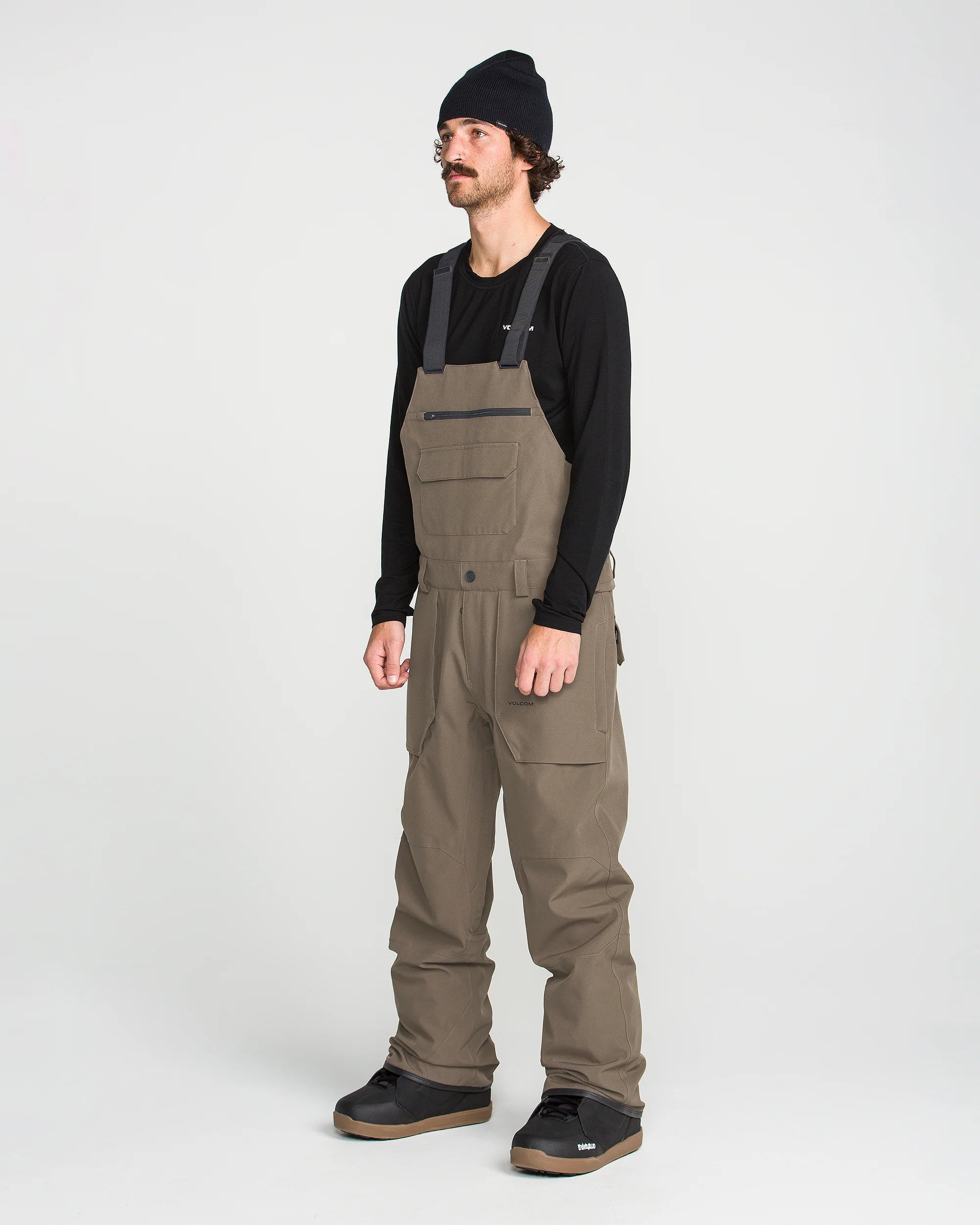 Brown bib overall worn with adjustable straps and front cargo pockets