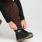 Close-up of brown snow pants fabric with front pocket and cinch detail