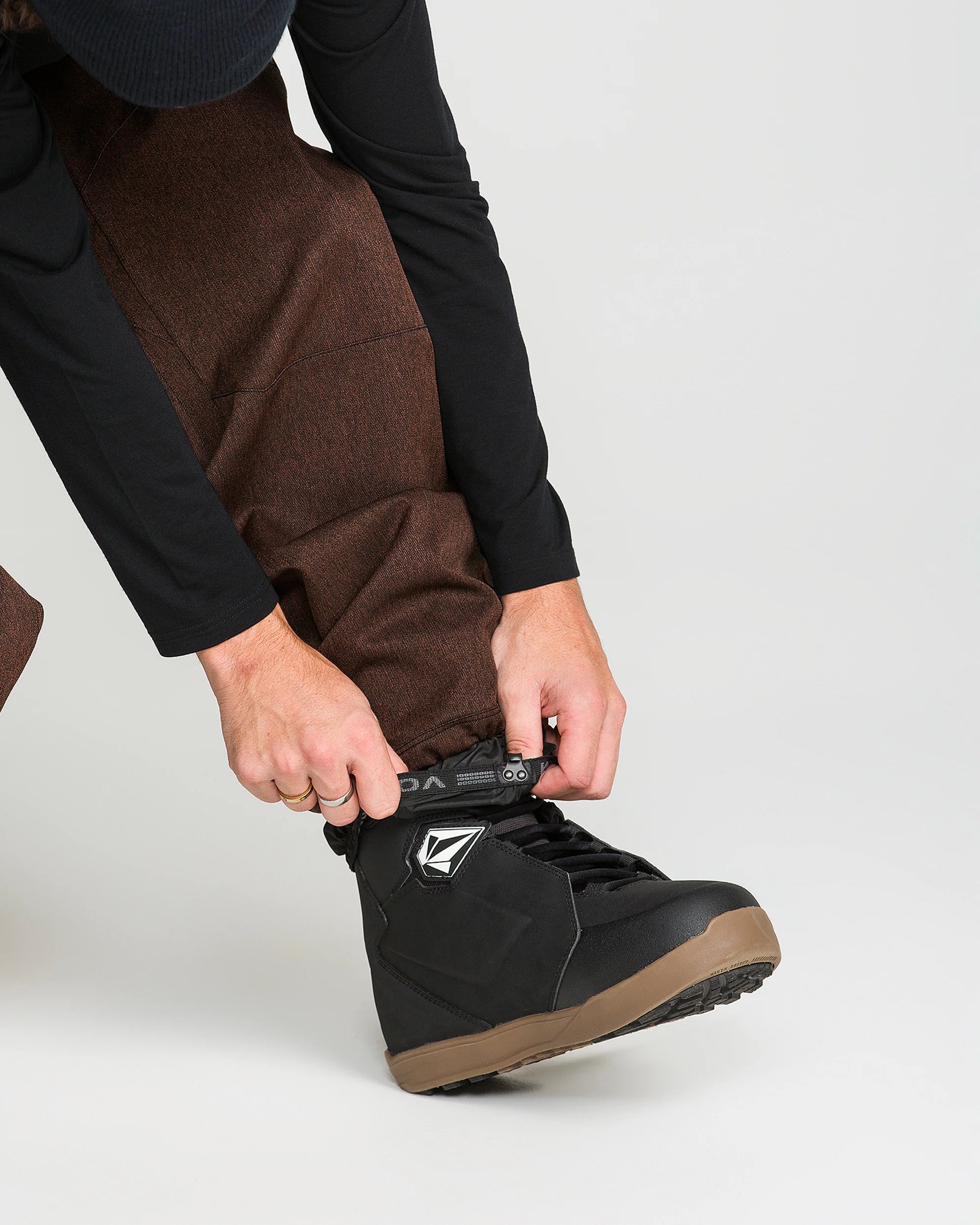 Close-up of brown snow pants fabric with front pocket and cinch detail