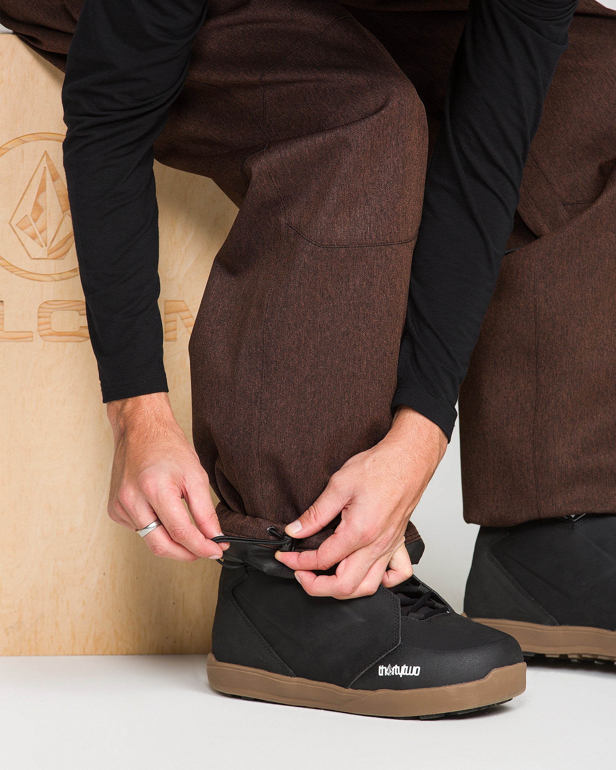Brown snow pants with front pocket and adjustable waistband detail
