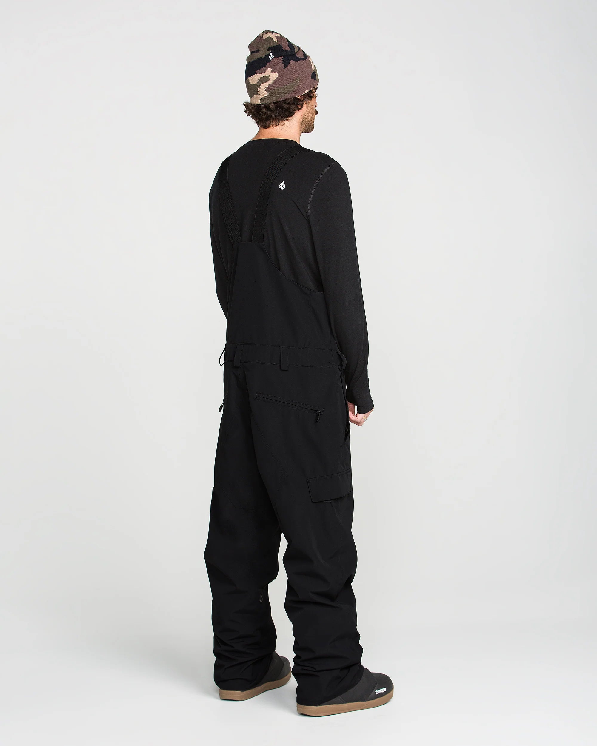 Black bib overall in back view with full-length legs and ankle cuffs