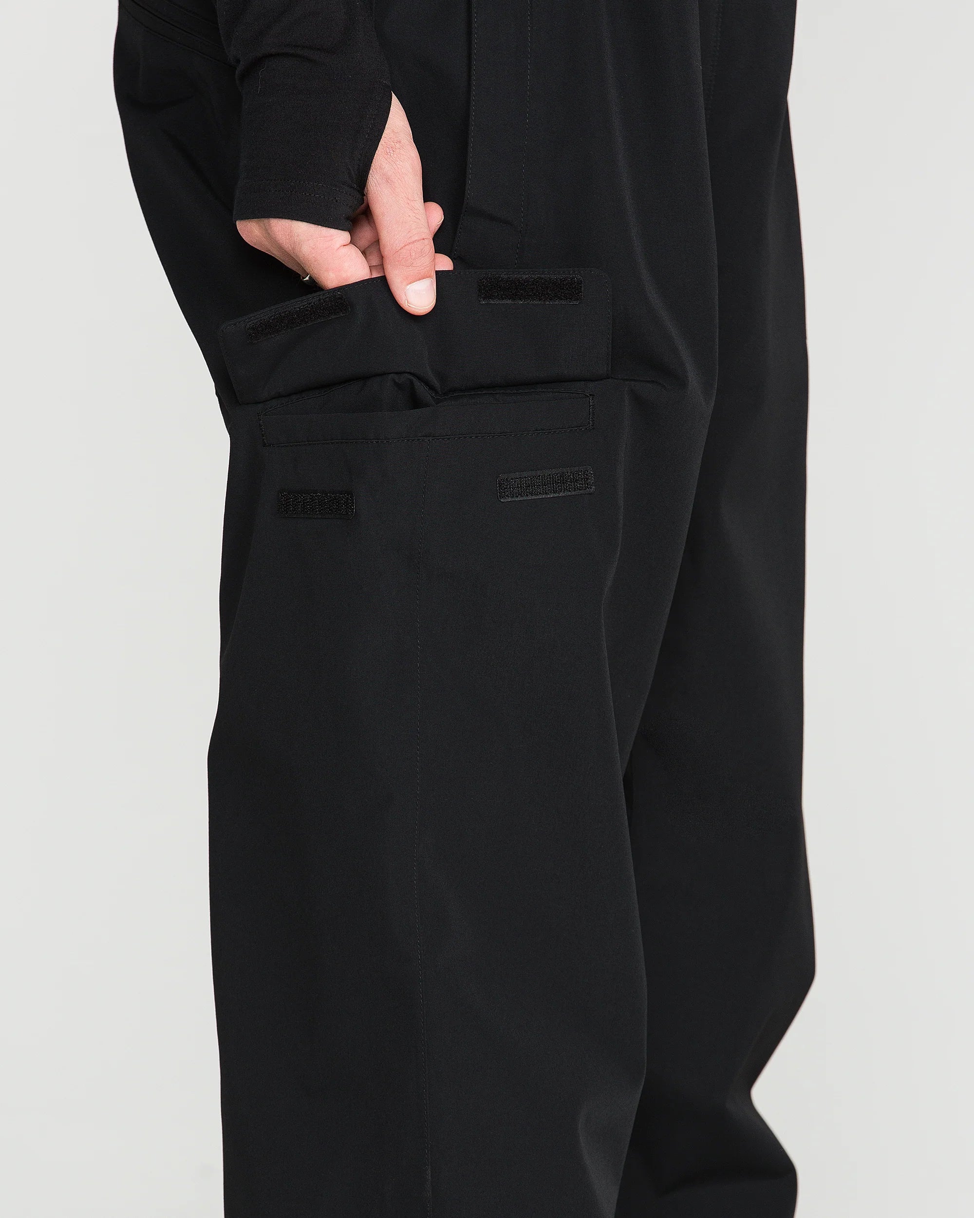 Black bib overall with front utility pocket panels and stitched seams