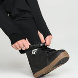 Black bib overall pant leg with cuff opening and logo patch at ankle