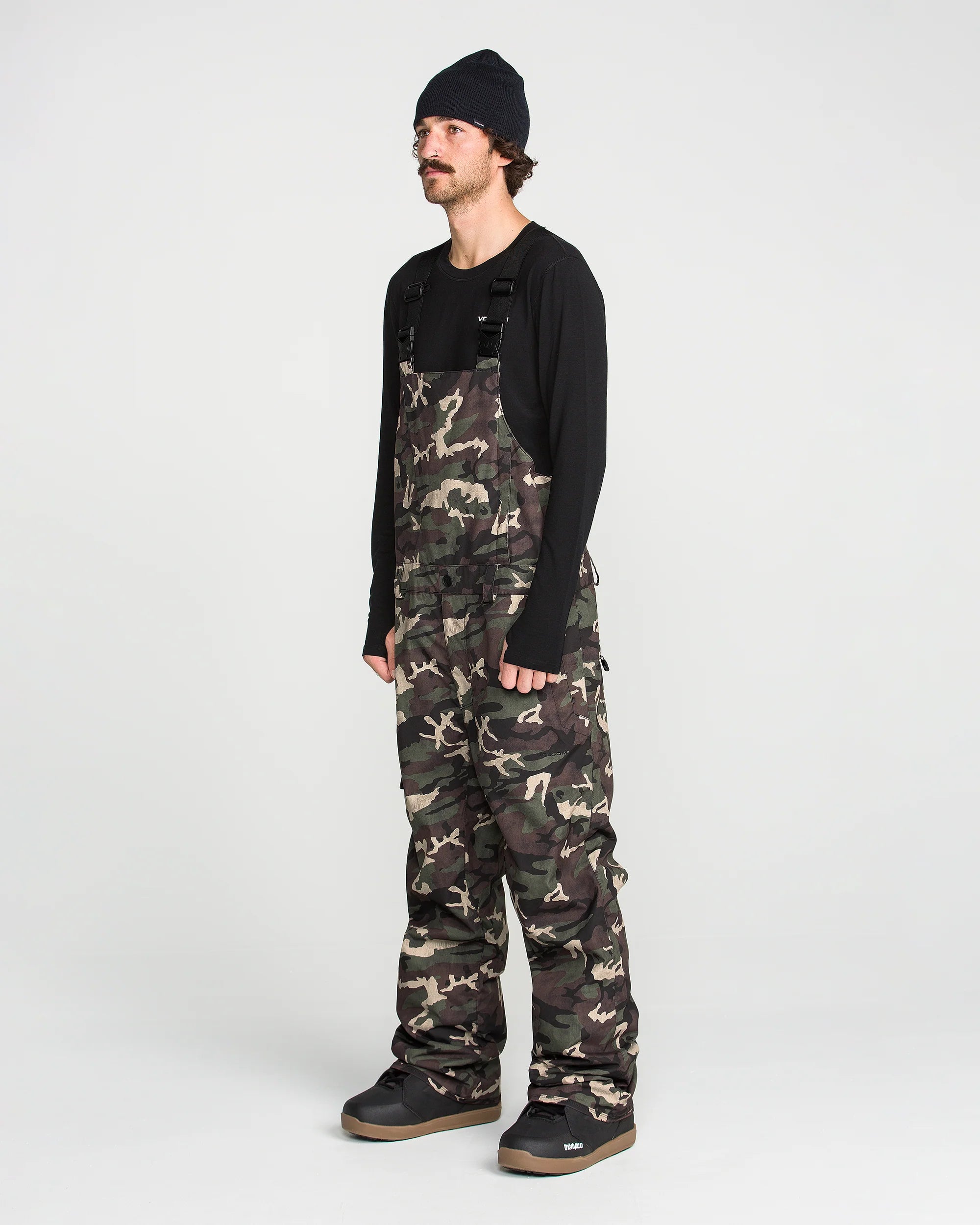 Camo bib overalls front worn full length with black long-sleeve top underneath