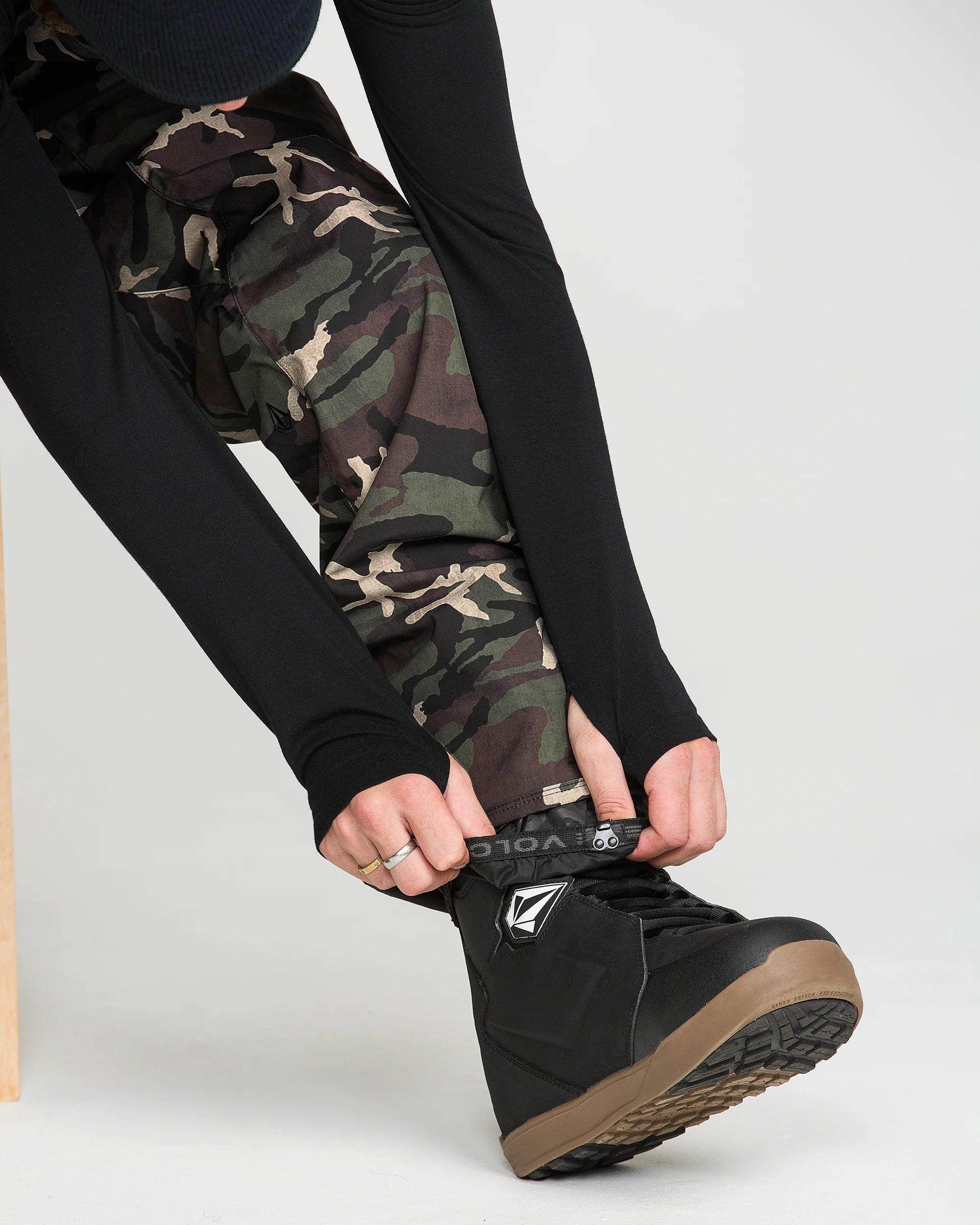 Camo bib overalls leg cuffs with black side panel and tan outsole boots