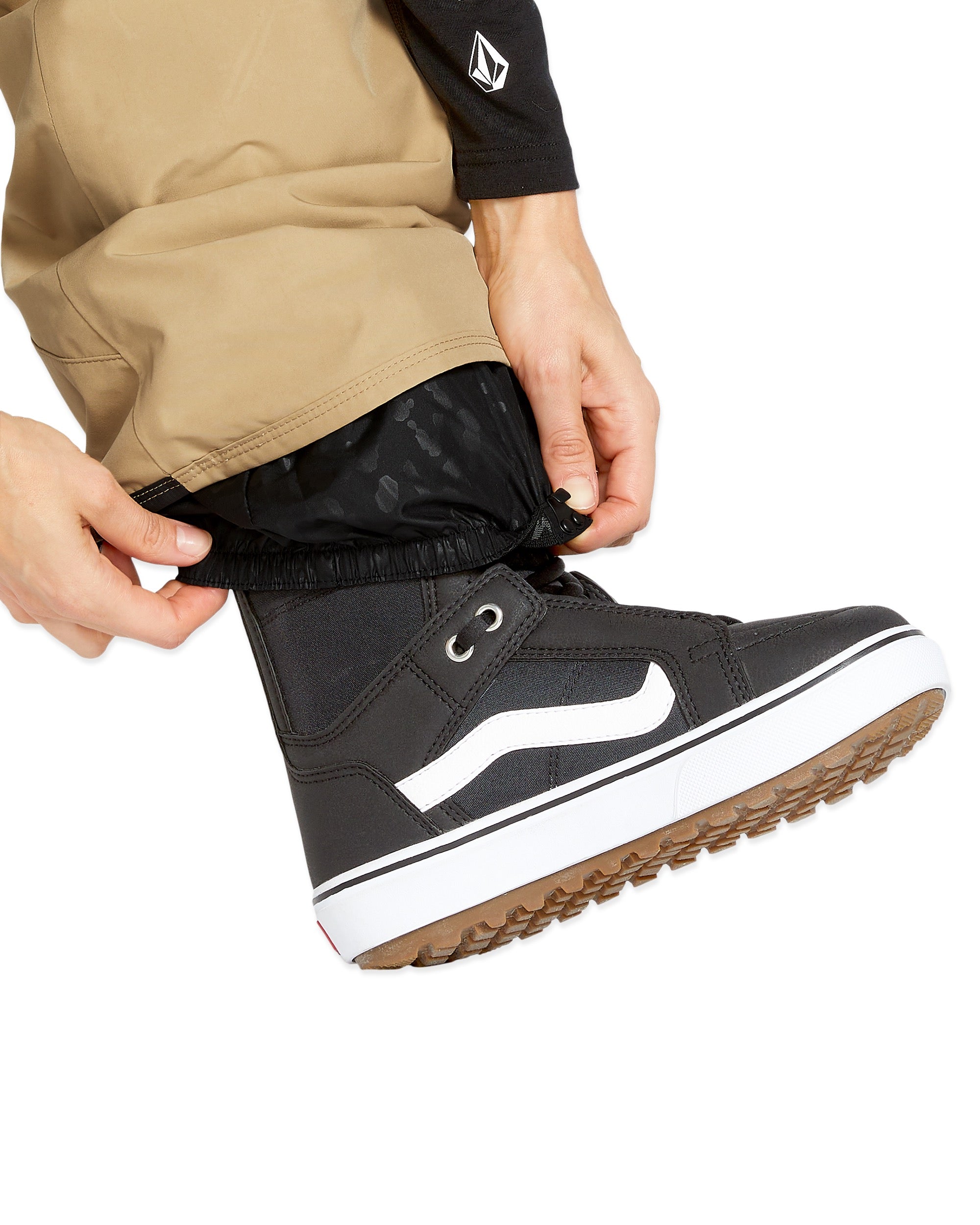 Volcom Women's Knox Insulated GORE-TEX Pant - A pair of black insulated ski pants with a subtle floral pattern on the lower leg, featuring a white logo on the left thigh and a zippered pocket on the right hip.