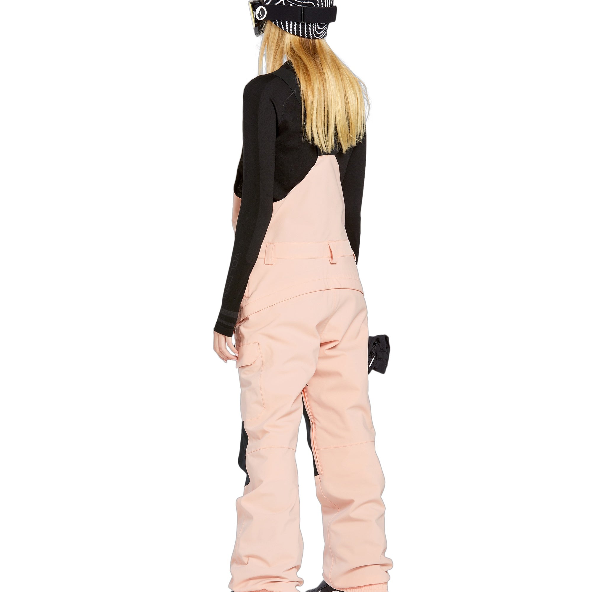 Volcom Women's Creston 3D Stretch Bib Overall - A pair of light pink snow bibs with a black stripe down the side and two front pockets.
