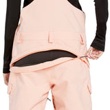 Volcom Women's Creston 3D Stretch Bib Overall - Light pink bib overalls with a black waistband and belt loops, featuring a zippered fly and two front pockets.