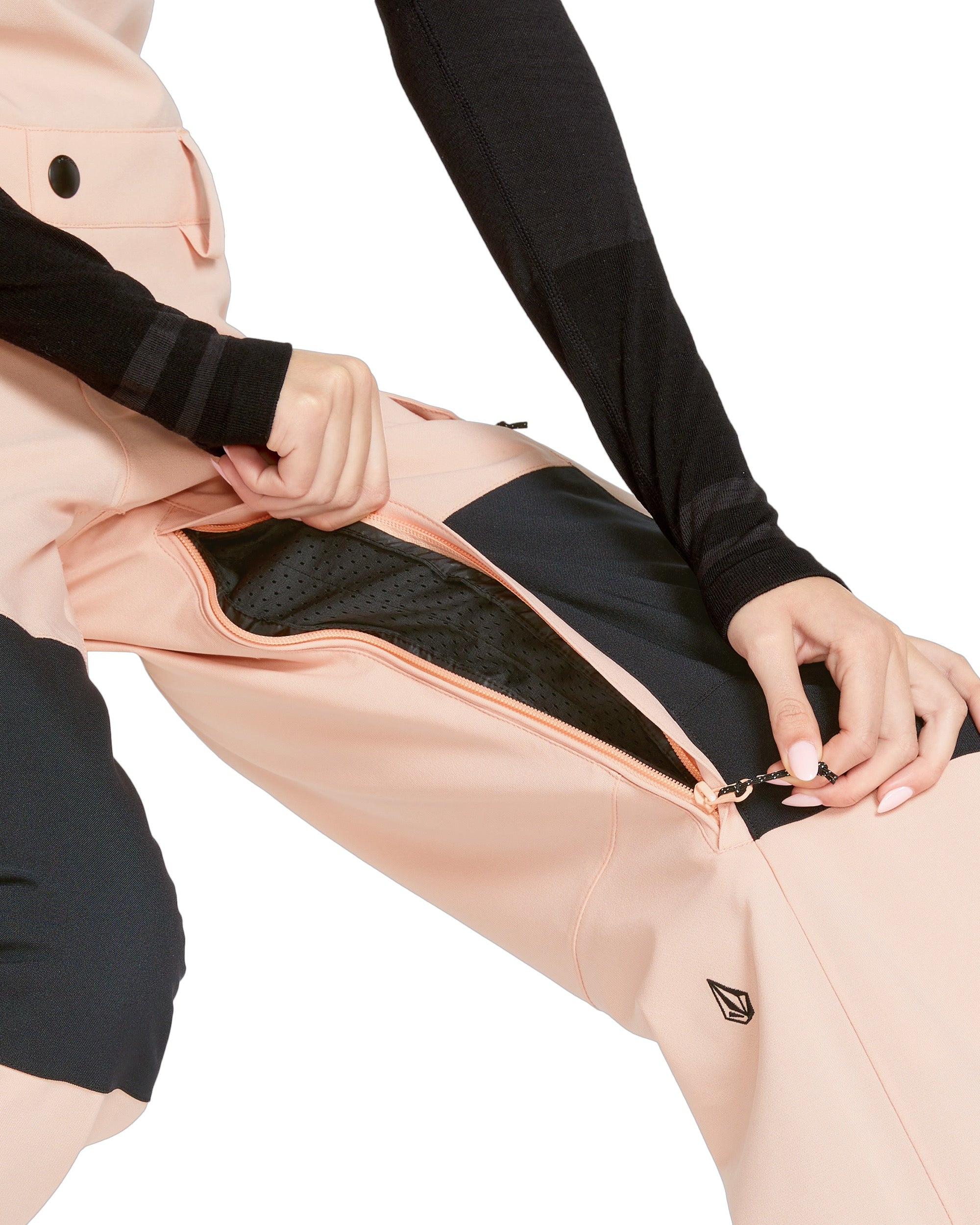 Volcom Women's Creston 3D Stretch Bib Overall - A light pink bib overall with a black logo on the left leg and a zipper running down the front.