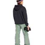 Volcom Women's Bridger Ins Pant 2025 - A pair of olive green snowboard pants with a zippered pocket on the thigh and adjustable Velcro straps at the waist.