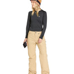 Volcom Women's Frochickie Insulated Pant - A pair of tan snow pants with a small white logo on the left thigh and a black zipper pull.