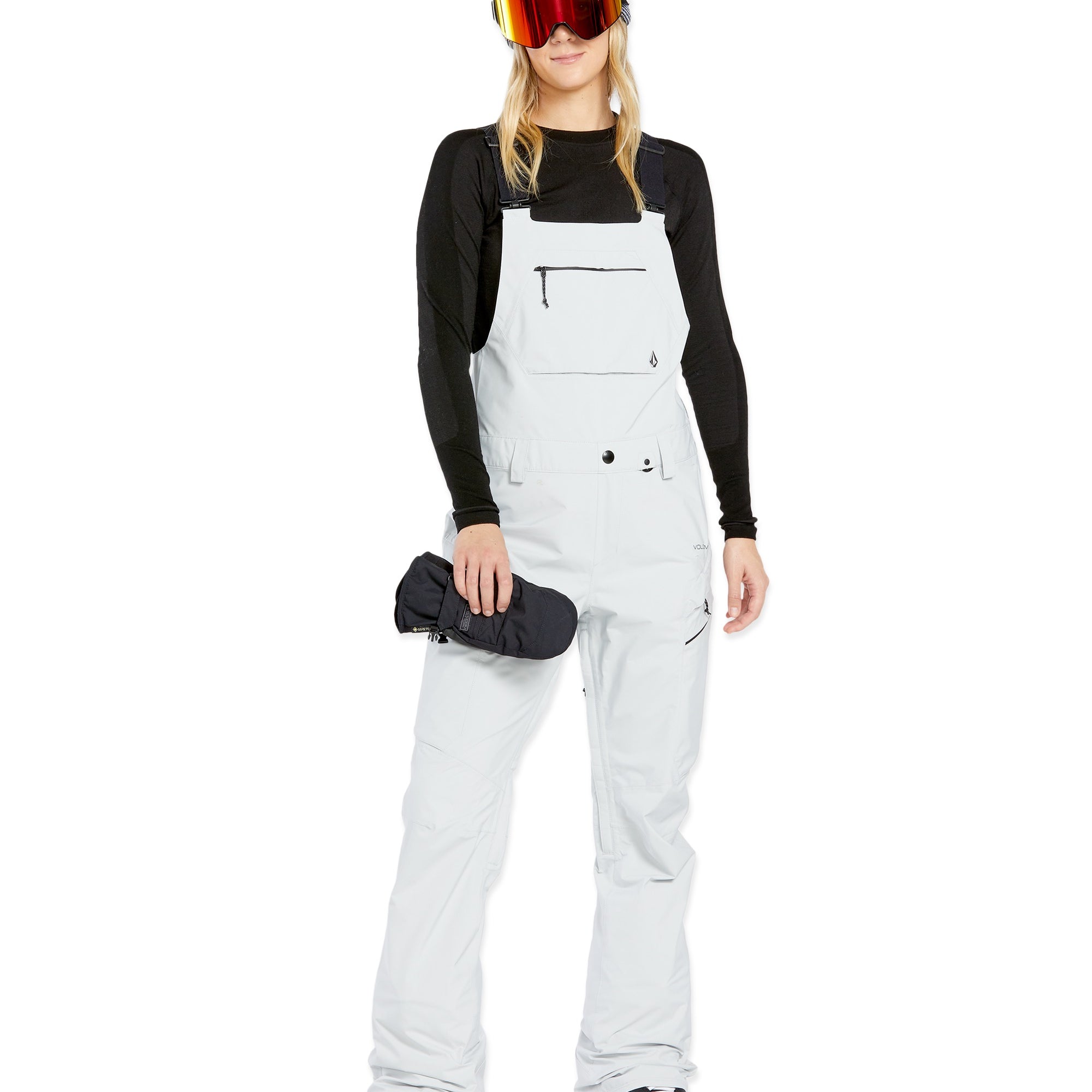 Volcom Women's Elm Stretch GORE-TEX Bib Overall - A pair of white snow pants with a black logo on the left thigh and a zippered pocket on the right thigh.