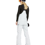 Volcom Women's Elm Stretch GORE-TEX Bib Overall - A pair of white snow pants with a black strap and zipper on the side, featuring a small pocket on the thigh.