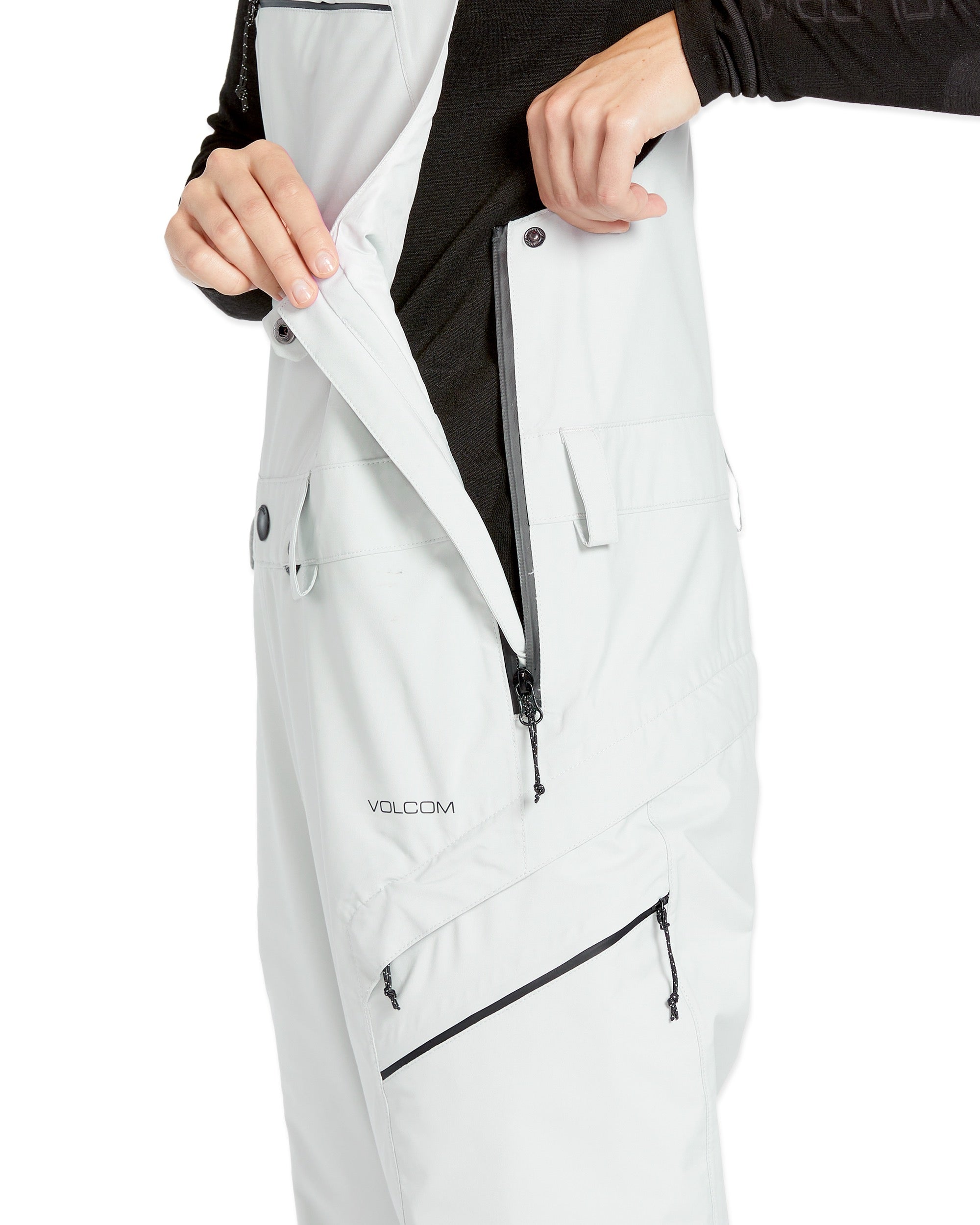 Volcom Women's Elm Stretch GORE-TEX Bib Overall - A white bib overall with a black logo on the left thigh and a black zipper running down the front.