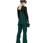 Volcom Women's Elm Stretch GORE-TEX Bib Overall - A pair of dark green snow pants with a stretchy material and multiple pockets, featuring a GORE-TEX logo on one pocket.