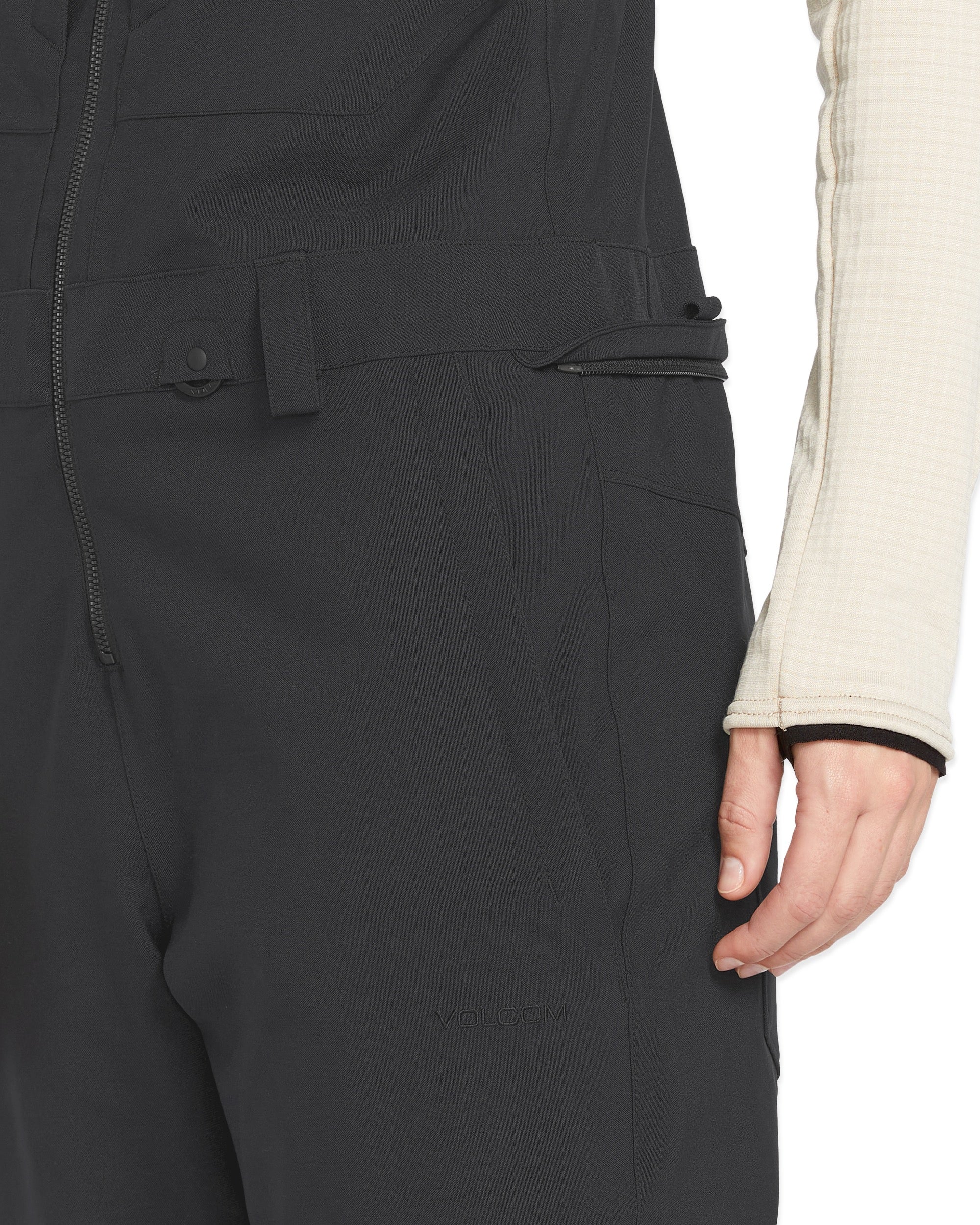 Volcom Women's Swift Bib Overall - A black bib overall with a zippered front and two side pockets, featuring a subtle "VOLCOM" logo on the left thigh.