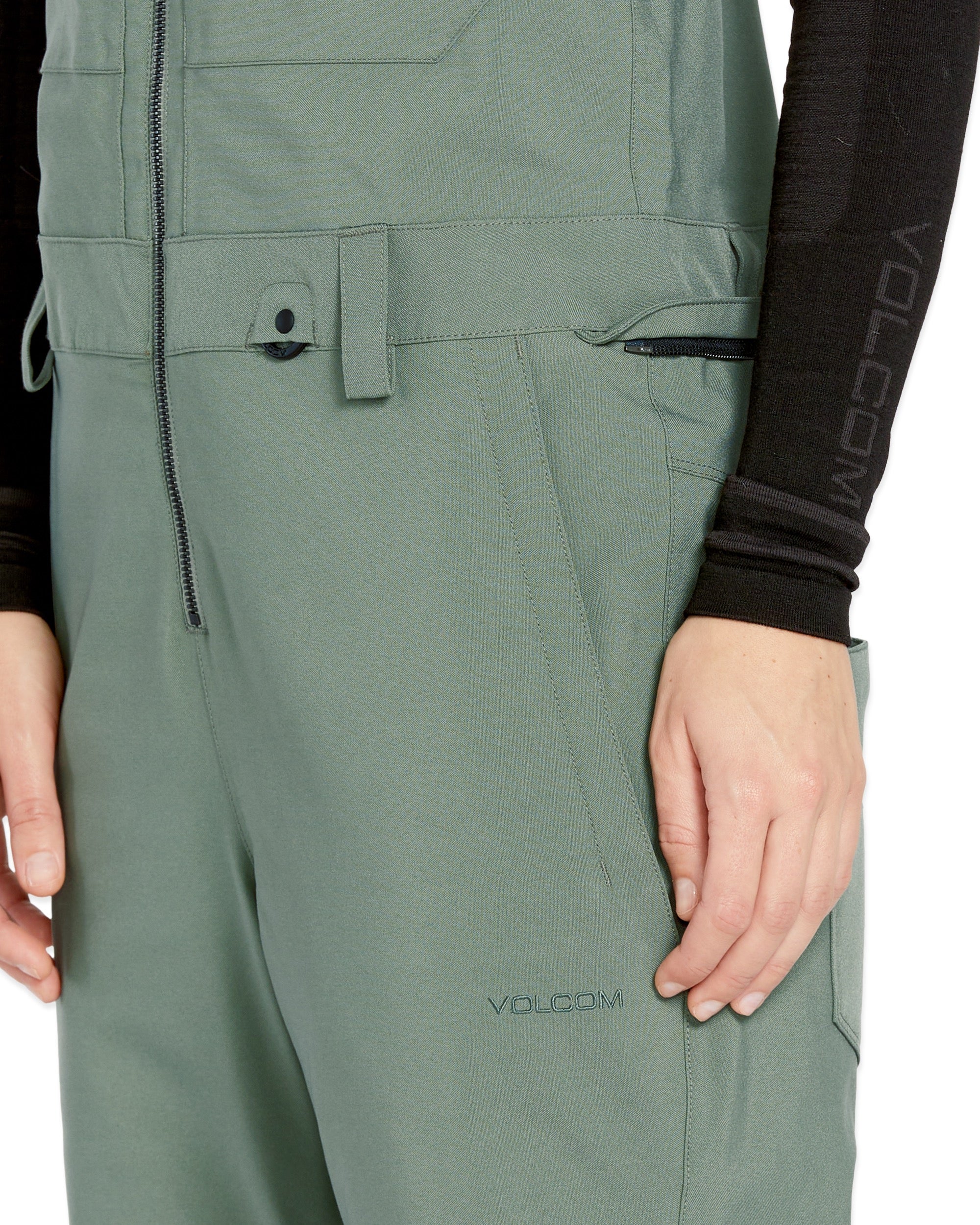 Volcom Women's Swift Bib Overall - A pair of olive green bib overalls with a zippered fly and adjustable straps.