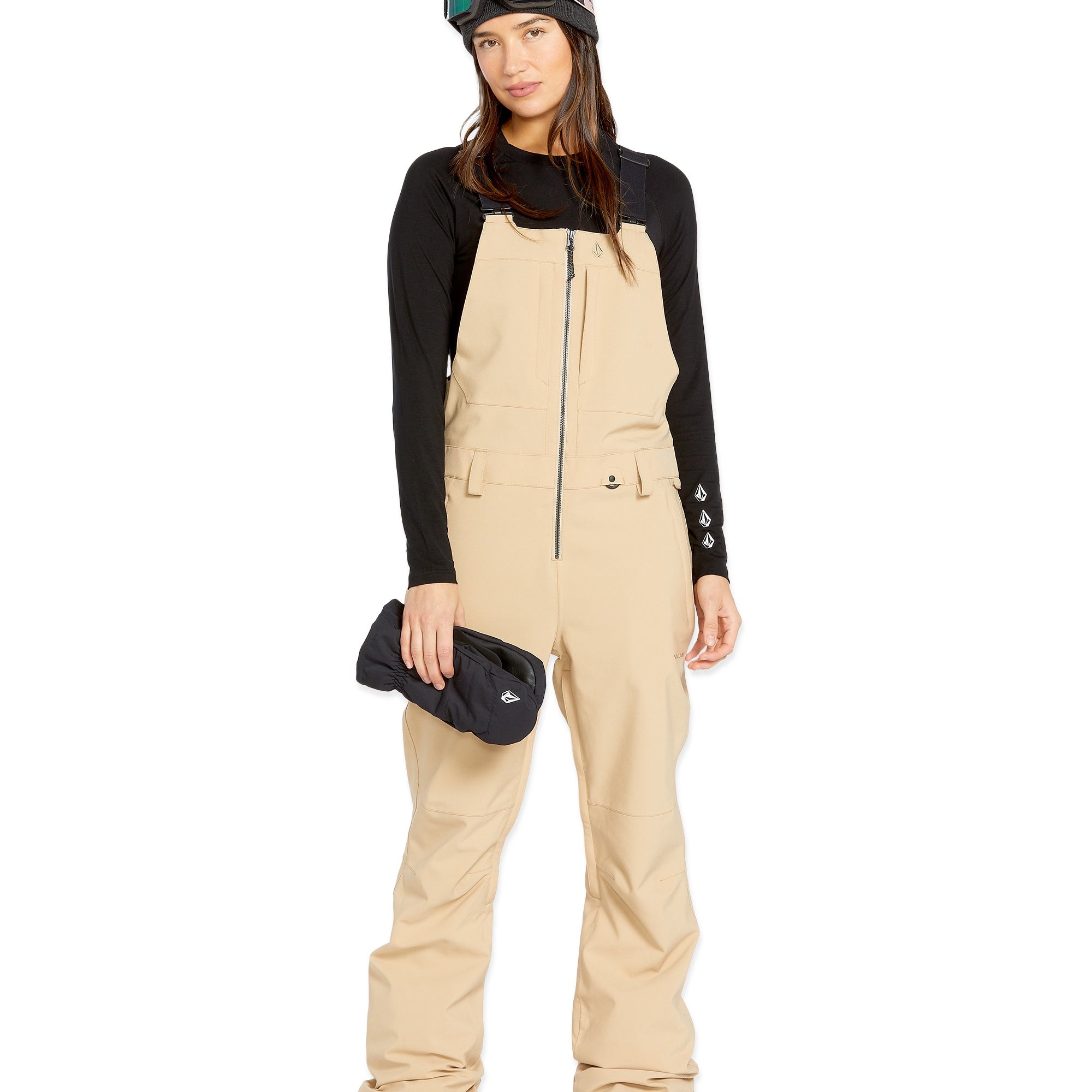 Volcom Women's Swift Bib Overall - A tan bib overall with a black zipper and two front pockets, featuring a small white logo on the right pocket.